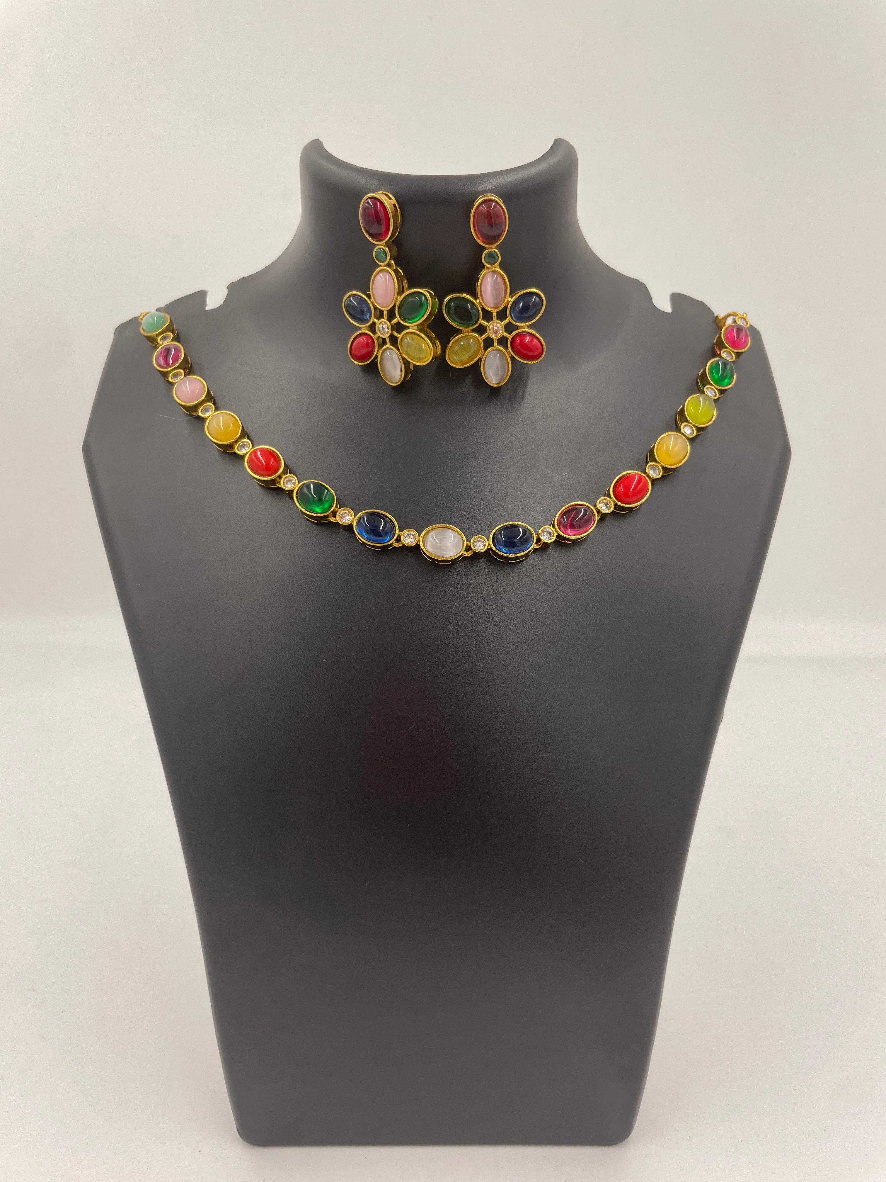 Navika Navarathna statement necklace featuring multicoloured stones in a gold-tone setting with matching floral-inspired statement earrings