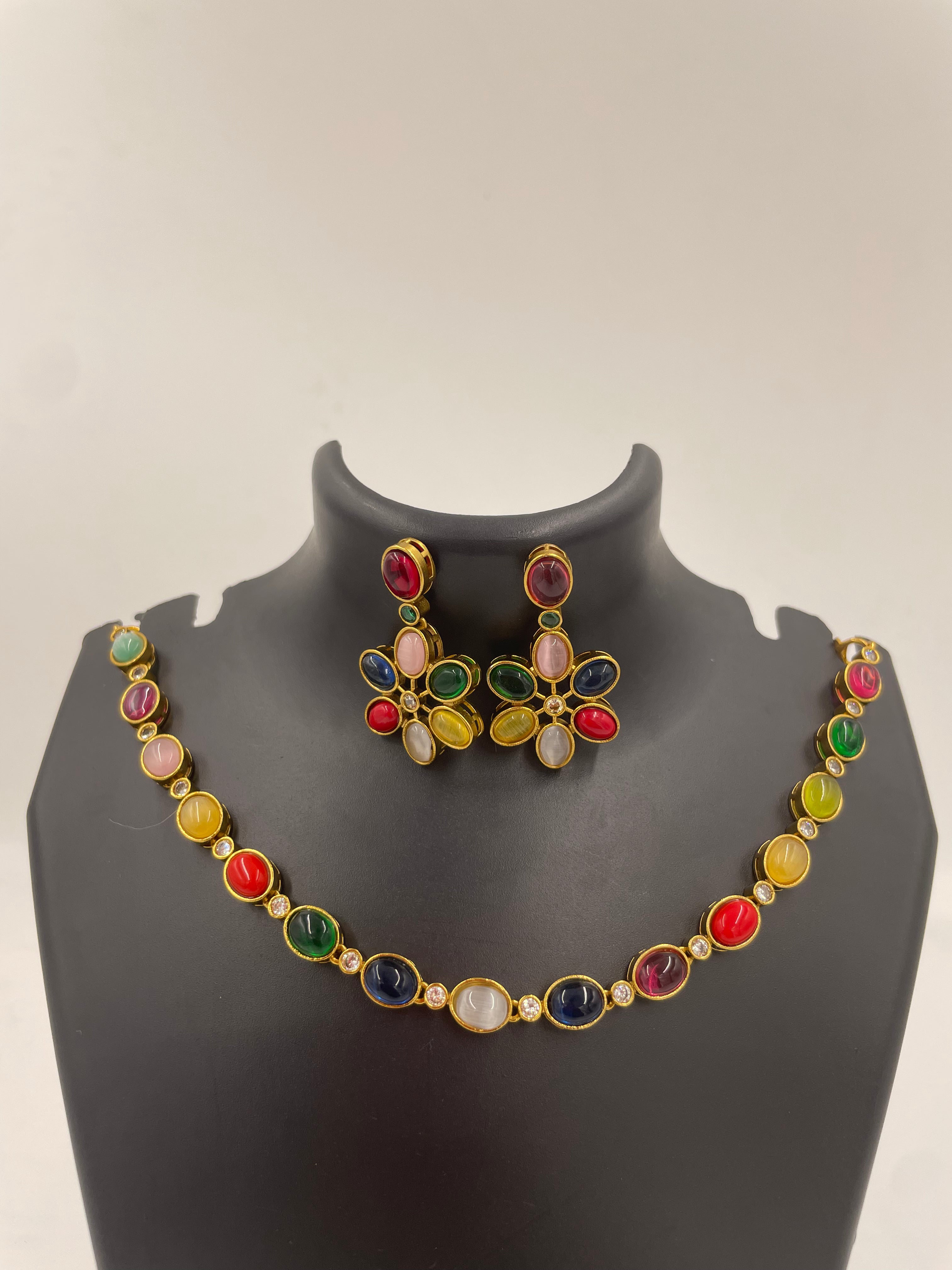 Navika Navarathna statement necklace featuring multicoloured stones in a gold-tone setting with matching floral-inspired statement earrings