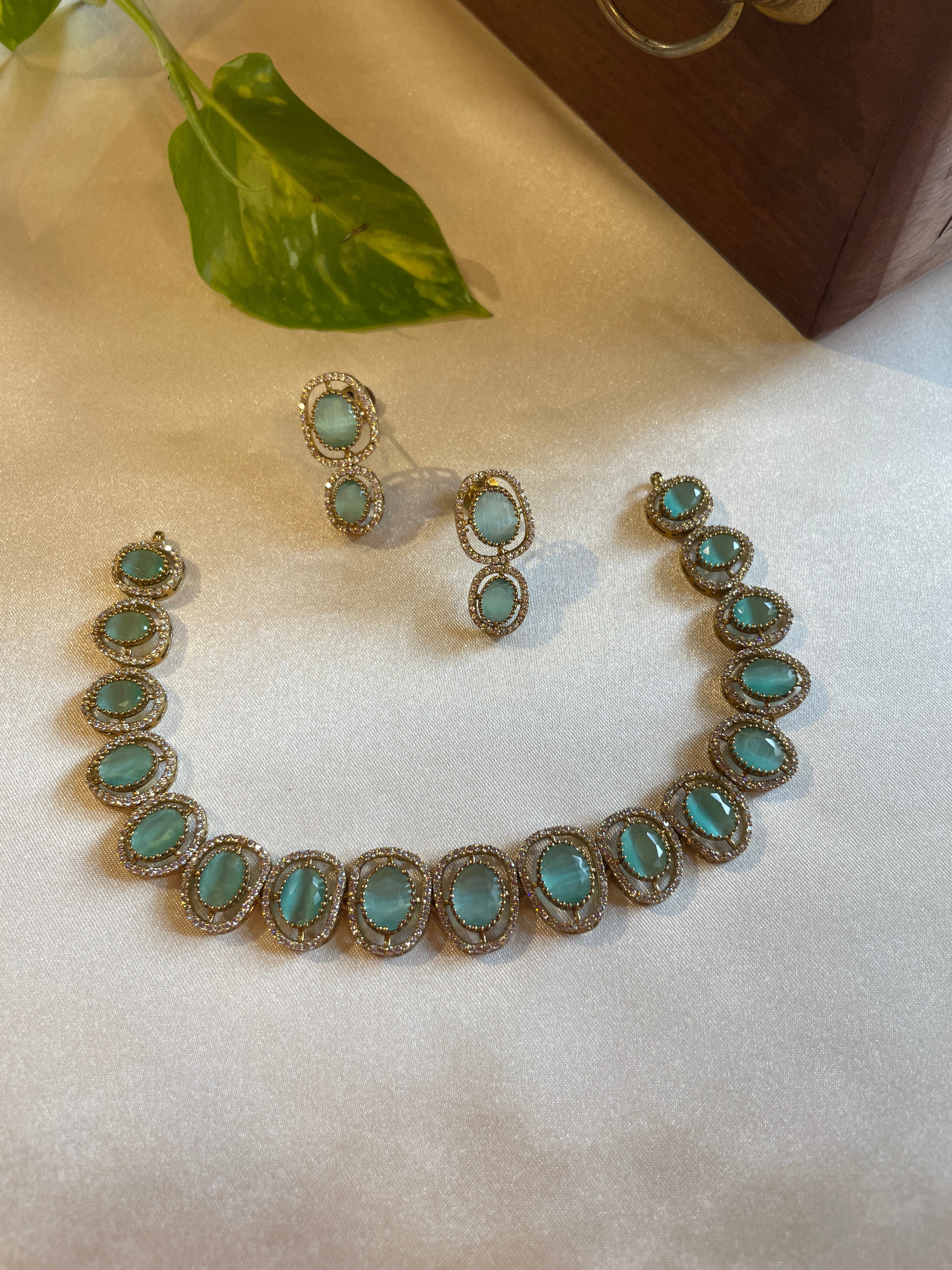 Celestine statement necklace featuring turquoise-toned oval stones with sparkling clear-stone borders and matching drop earrings
