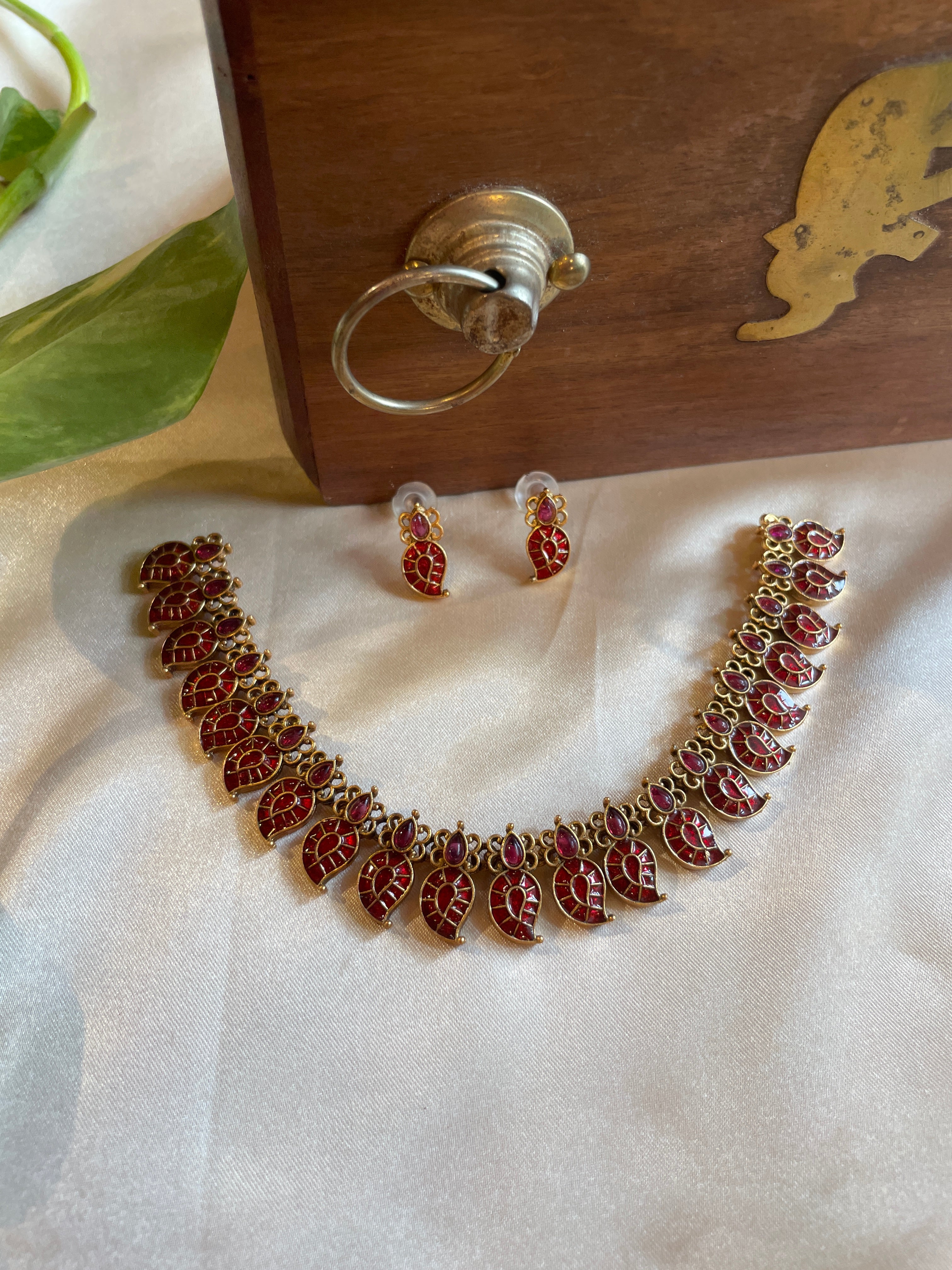 Amalu traditional Palakka necklace featuring maroon hand-painted enamel leaf motifs, gold-tone detailing and matching earrings