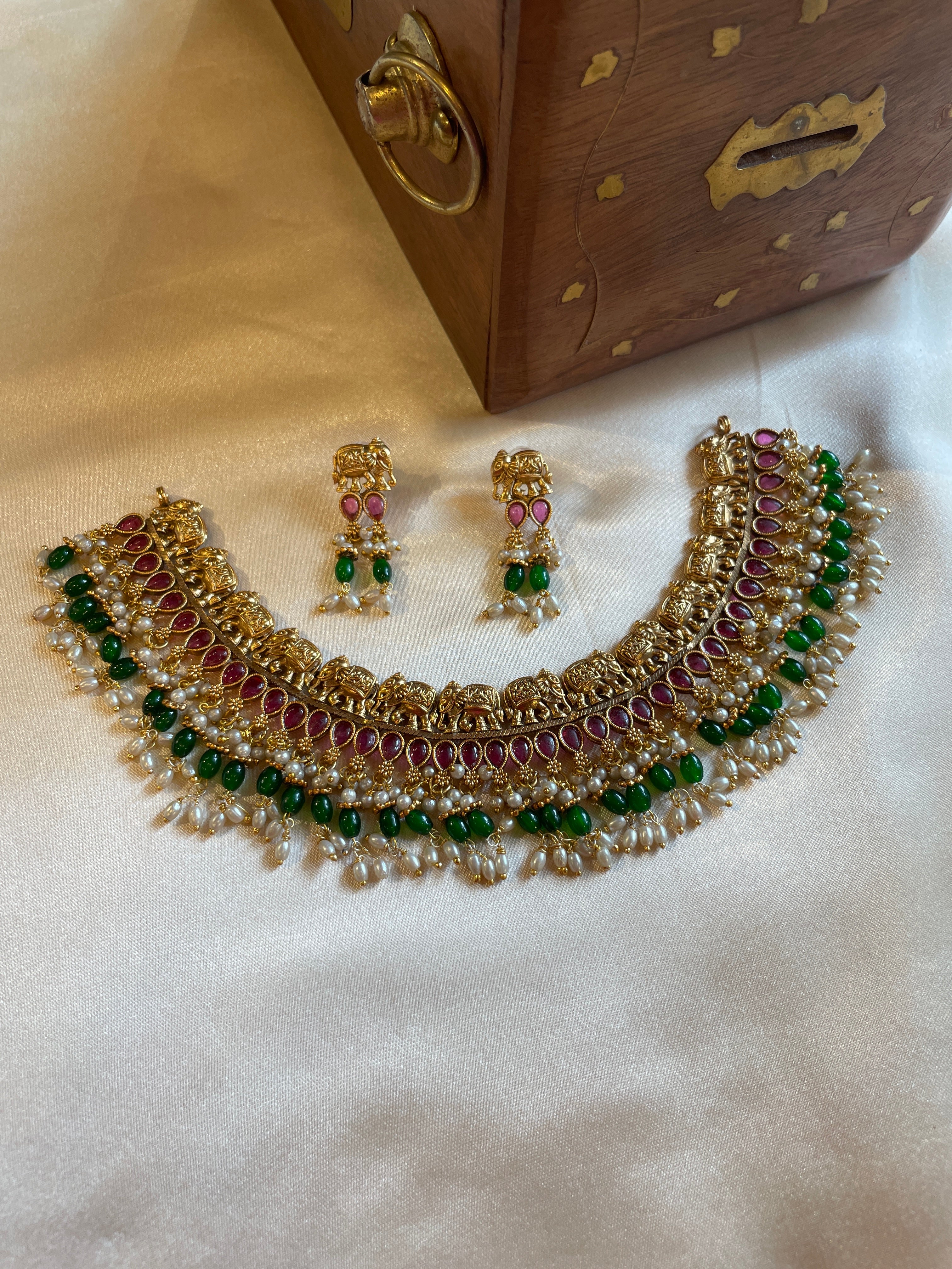 Vaidehi micro gold plated South Indian temple necklace set with ruby-coloured stones, green beads and pearl hangings with matching earrings