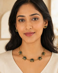 Padma gold-tone necklace with five black lotus motifs and matching lotus stud earrings.