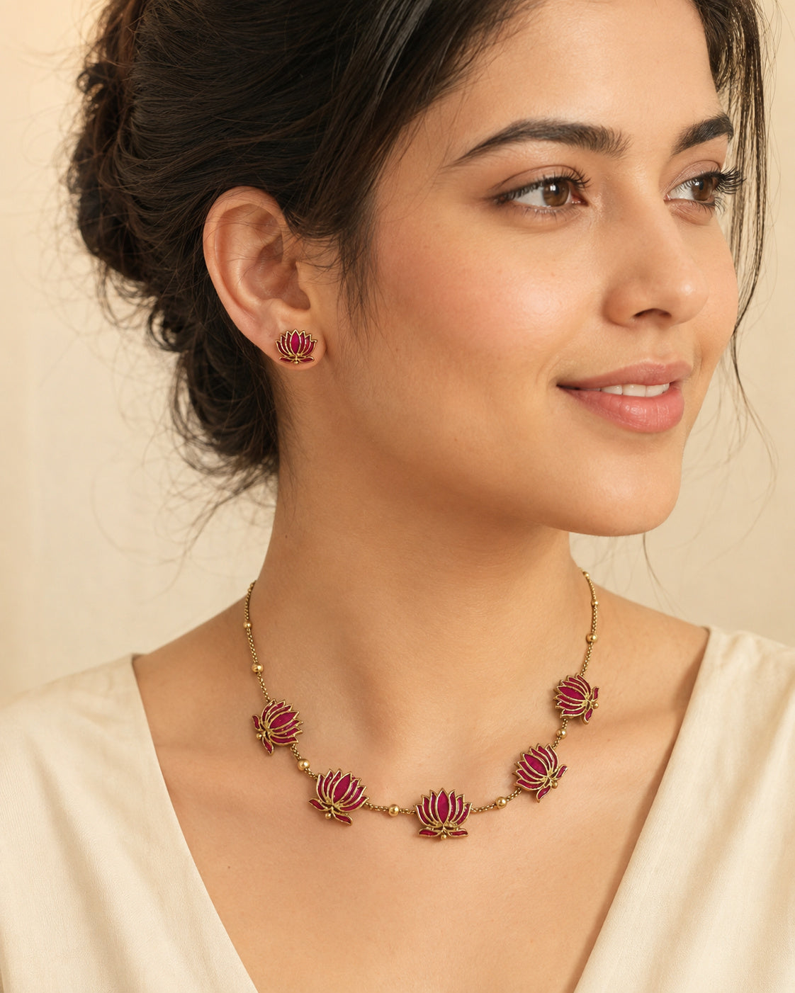 Padma gold-tone necklace with five pink lotus motifs and matching lotus stud earrings.